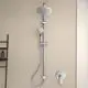 Duschsystem von Ideal Standard mit großer oberer Brause und Handbrause, montiert an der Wand, vor einem hellen Hintergrund.